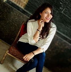 Portrait of a smiling young woman sitting outdoors