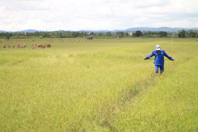 Full length of woman walking on field against sky