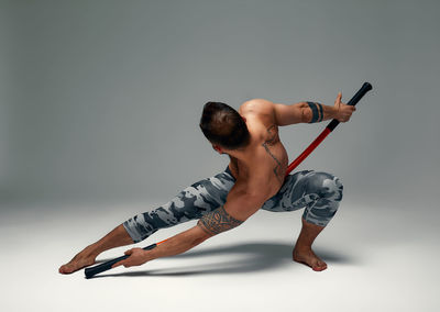 Low angle view of man exercising against white background