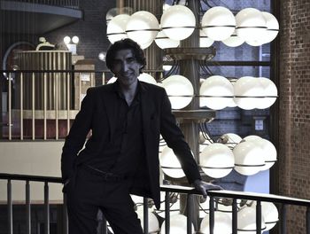 Teatro piccolo riggio, torino. italy. portrait of young man standing against railing 