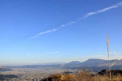 Scenic view of vapor trails against blue sky