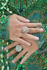 Midsection of woman in green dress wearing rings