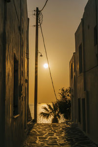 Street amidst buildings against sky during sunset