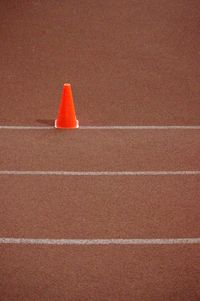 High angle view of red traffic cone on running track