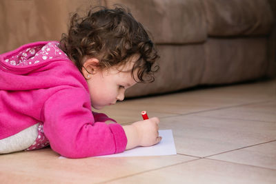 Girl drawing on paper at home