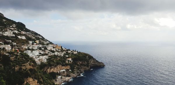 Scenic view of sea by buildings against sky