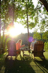 People relaxing on chair in yard during sunny day