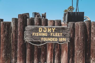 Close-up of text on wood against clear sky