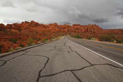 Road leading towards mountains against sky