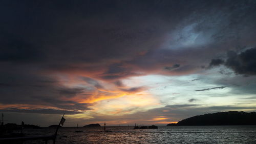 Scenic view of sea against dramatic sky during sunset