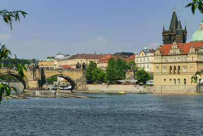 Arch bridge over river against buildings in city