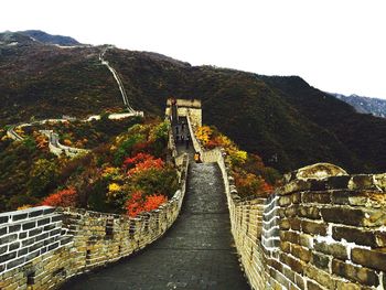 Great wall of china by mountains against clear sky during autumn