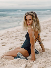 Portrait of young woman standing at beach