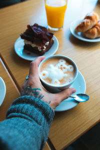 Midsection of man holding coffee cup