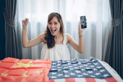 Portrait of smiling young woman holding hands at home