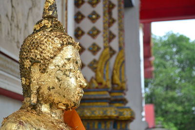 Close-up of buddha statue against building