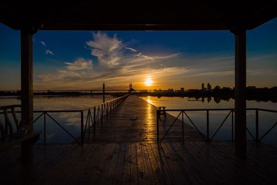 Pier over sea against sky during sunset