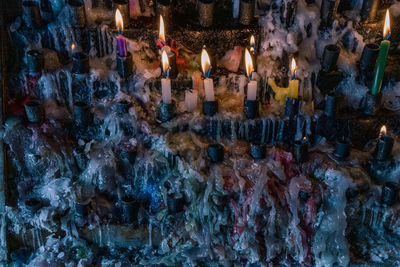 Panoramic view of lit candles in temple
