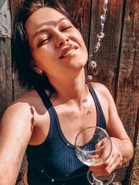 Portrait of a smiling young woman drinking glass