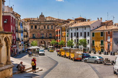 People on street amidst buildings in city