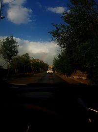 Cars on road against sky in city