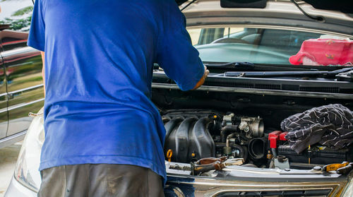 Low section of man working on motorcycle