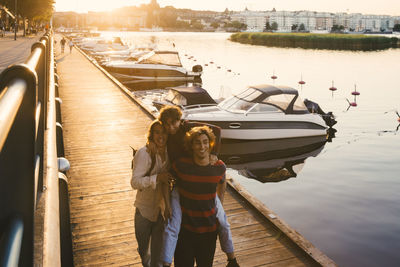 People standing on boat moored in lake