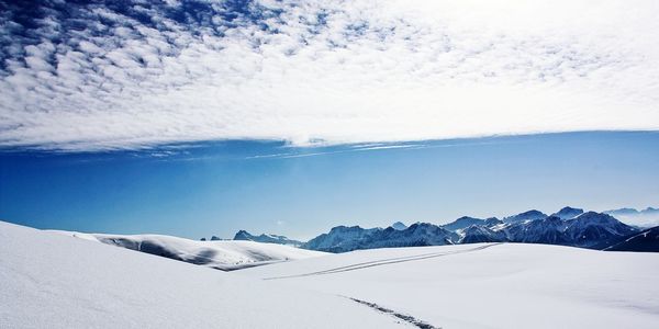 Scenic view of snow covered field against sky