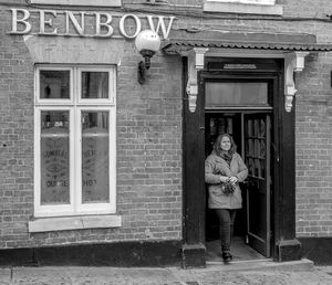 Portrait of man standing at entrance of house