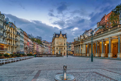 Buildings in city against cloudy sky