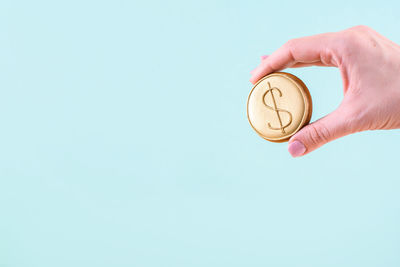 Midsection of person holding ice cream against blue background