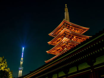 Low angle view of illuminated buildings against sky at night