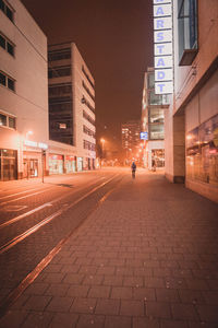 City street amidst buildings at night