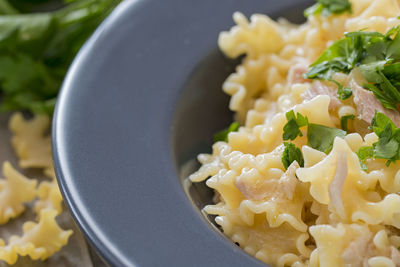 A plate with mafalda pasta with tuna and parsley.