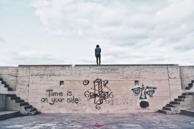 Man with text against sky