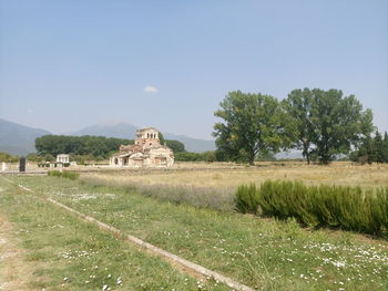 Houses on field against clear sky
