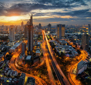 High angle view of illuminated city against sky during sunset