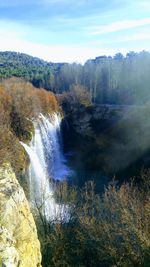 Scenic view of waterfall against sky