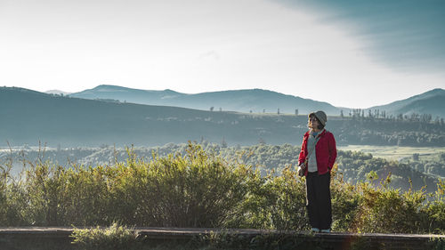 Rear view of woman standing against mountain