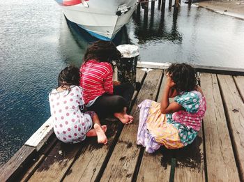 Girls sitting on pier