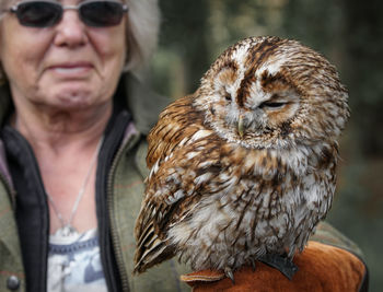 Close-up of senior woman with owl