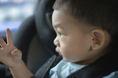 Close-up portrait of cute boy in car