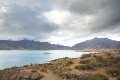 Scenic view of land and mountains against sky