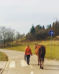 Rear view of woman walking on road
