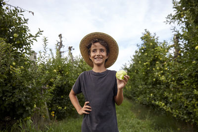 Happy child picking apples in an apple farm