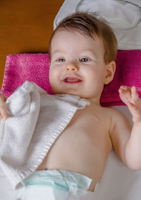 Portrait of cute baby girl lying on sofa