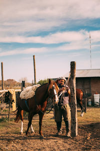 Portrait of man taking care of his horse in countryside