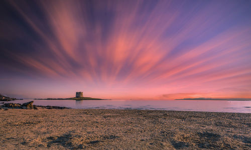 Sunrise on the beach of la pelosa, in the small city of stintino, with dramatic cloudy sky of summer