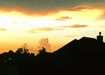 Low angle view of silhouette buildings against sky at sunset