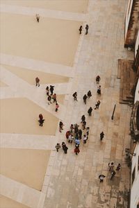 High angle view of people walking on tiled floor